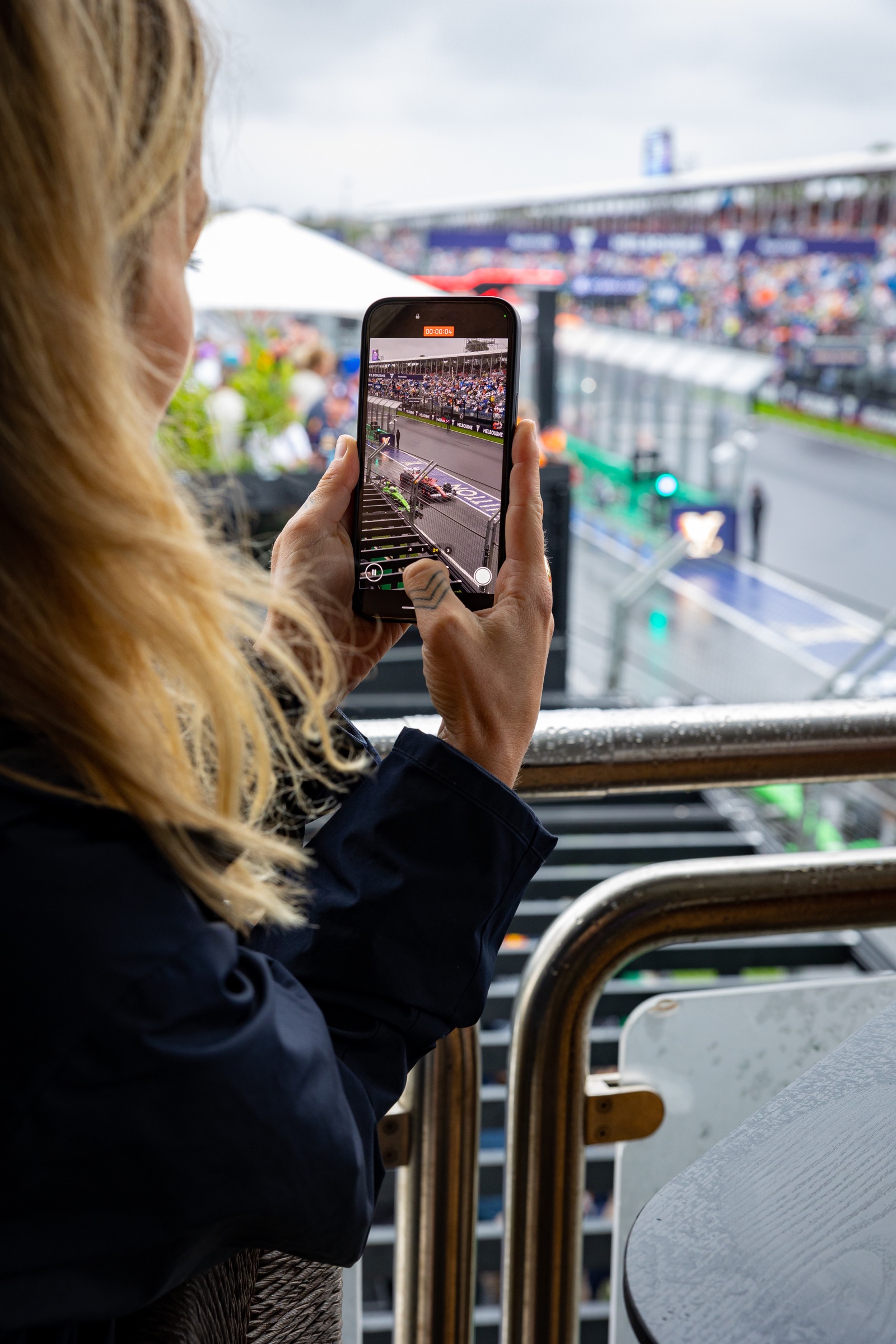 Guest filming the Formula 1 race from a hospitality suite